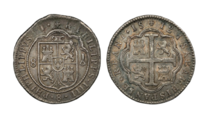 Two irregularly shaped Spanish Colonial 8 Reales silver "cob" coins recovered from a 1715 Fleet shipwreck, showing the Cross and Shield designs.