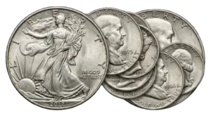A montage of circulated 90% U.S. silver coins, including Walking Liberty and Franklin Half Dollars, used as tangible silver assets.