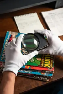 Collector examining vintage comics with a loupe to judge condition and value