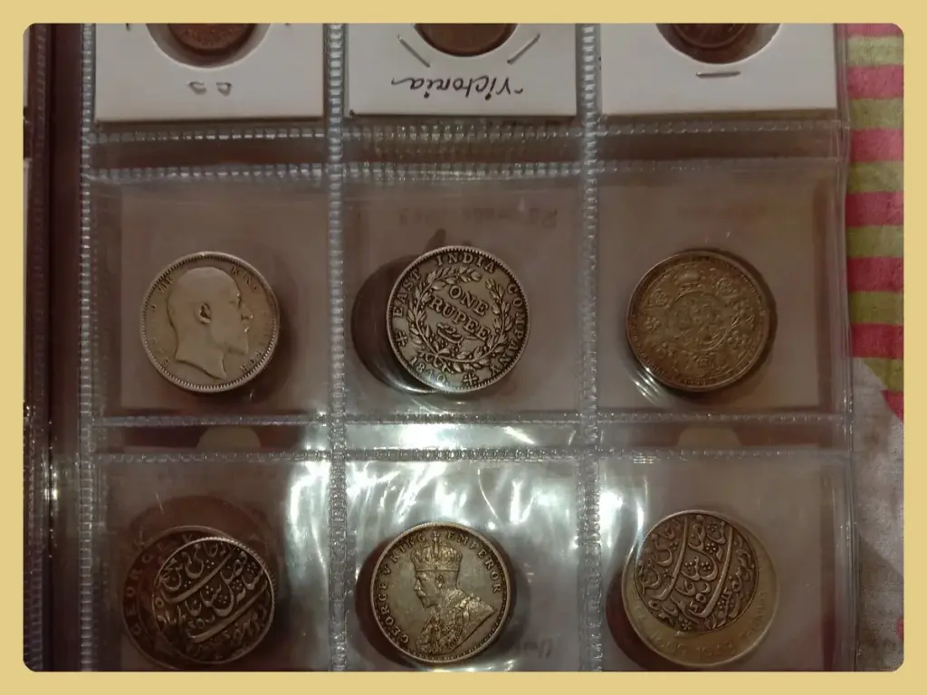 Silver coins in cardboard 2x2 holders with clear windows arranged in a plastic album page