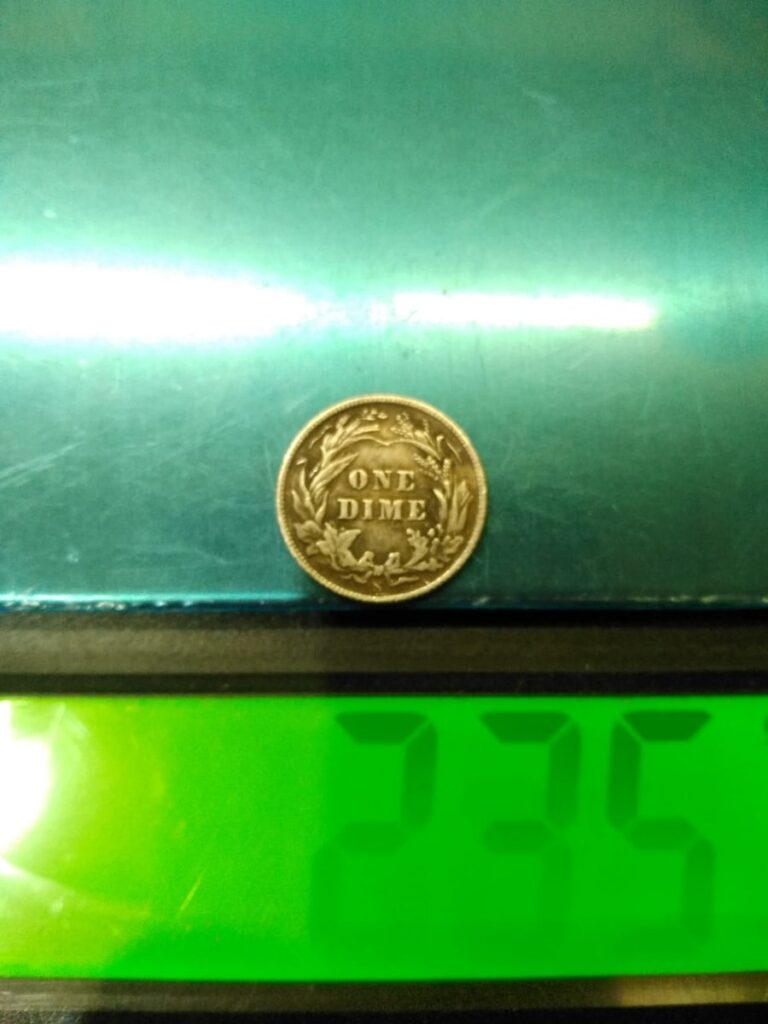 Counterfeit 1894 Barber dime, reverse, on a scale