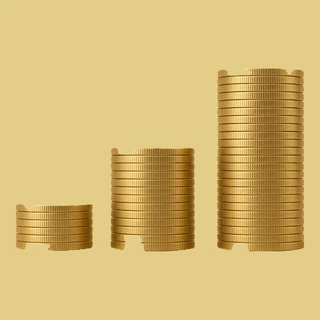 Tres pilas de monedas de oro ordenadas por tamaño, que muestran cómo clasificar y contar las monedas antes de venderlas