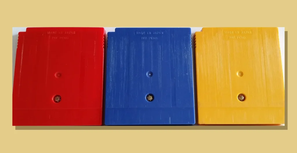 Back of red, blue and yellow original Pokemon Game Boy game cartridges lined up side by side