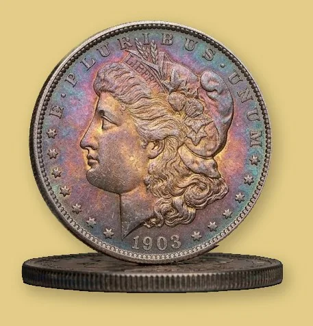 1903 Morgan silver dollar with natural rainbow toning standing on edge on another silver dollar