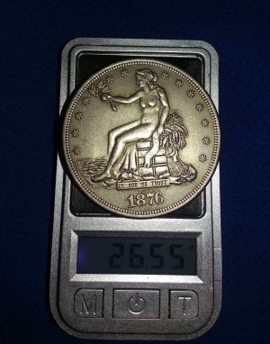 A fantasy coin on a scale, showing a weight test used to identify non-genuine and counterfeit coins.