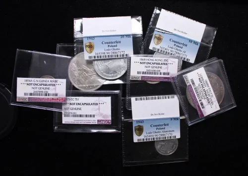 A group of counterfeit coins returned in "body bags" by grading services, proving the need for expert authentication.